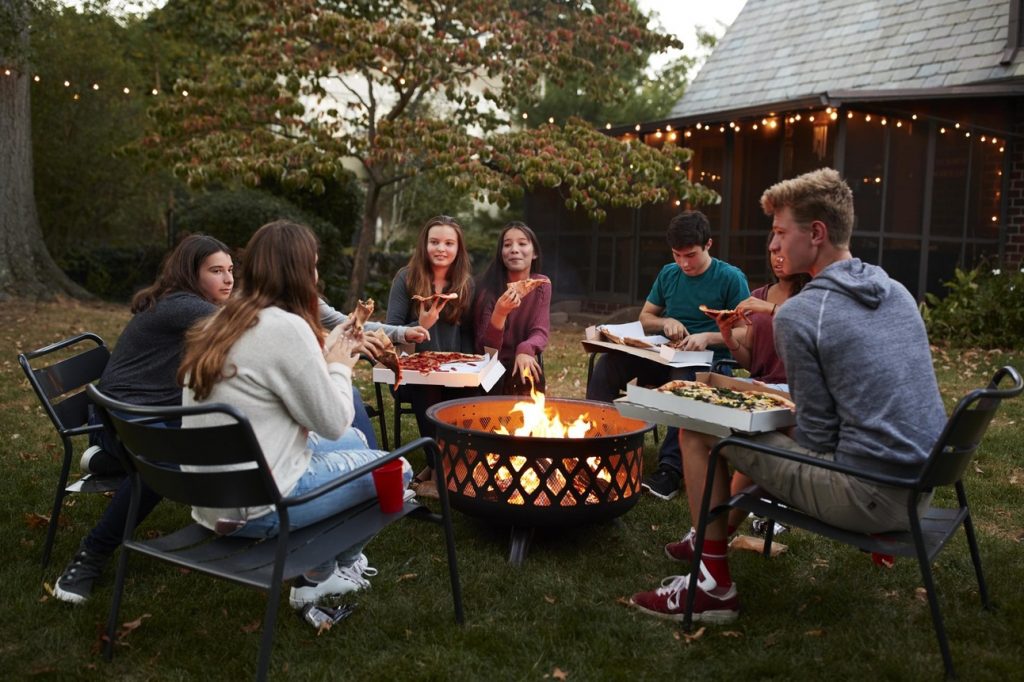 friends sitting around a portable fire pit