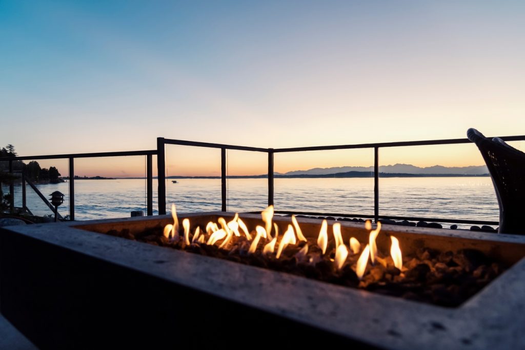 rectangular fire pit on backyard patio at water front property