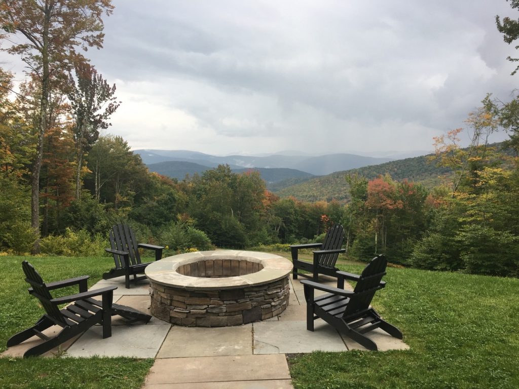 stone fire pit stone pavers patio on hillside backyard